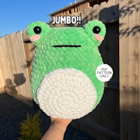 a green frog stuffed animal with the words jumbo